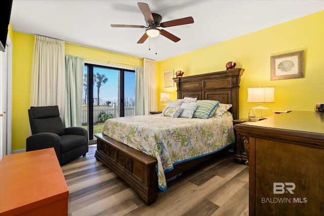 bedroom with access to outside, wood finished floors, and a ceiling fan