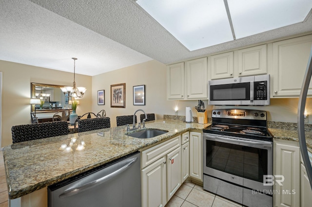 kitchen featuring kitchen peninsula, a textured ceiling, stainless steel appliances, sink, and light tile patterned floors