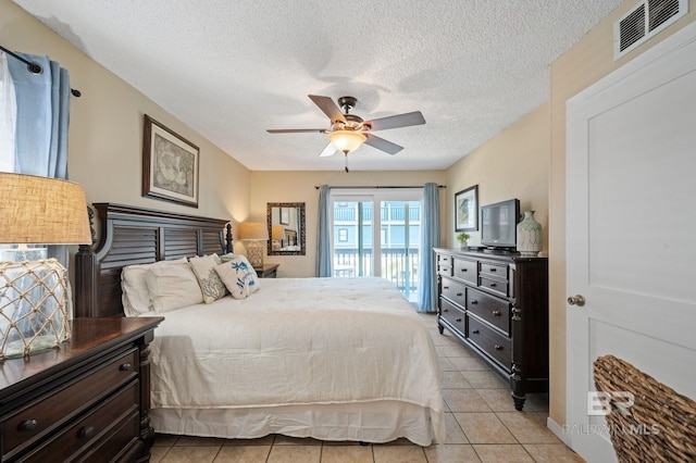 tiled bedroom with ceiling fan, a textured ceiling, and access to outside