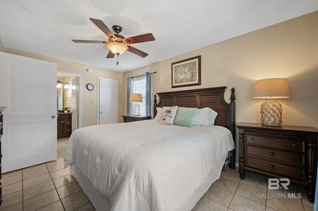 bedroom with ceiling fan, light tile patterned flooring, a textured ceiling, and ensuite bath