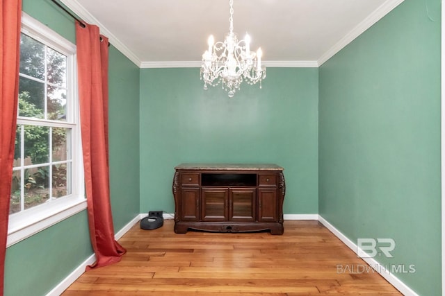 dining space featuring a wealth of natural light, ornamental molding, a chandelier, and light hardwood / wood-style flooring