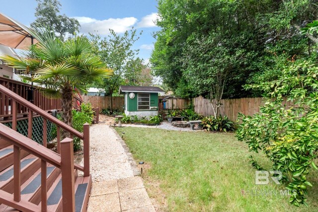 view of yard with a wooden deck and a storage unit