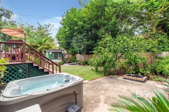 exterior space featuring a patio area, a storage shed, and a hot tub