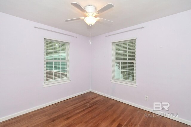 empty room featuring dark hardwood / wood-style flooring and ceiling fan