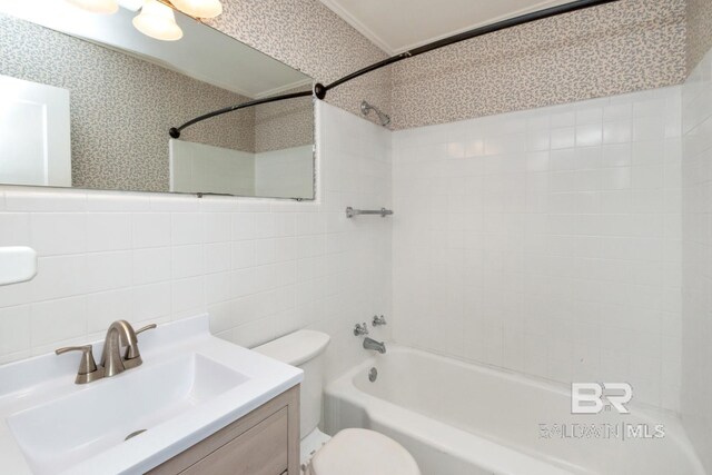 full bathroom with toilet, tile walls, tiled shower / bath combo, decorative backsplash, and vanity