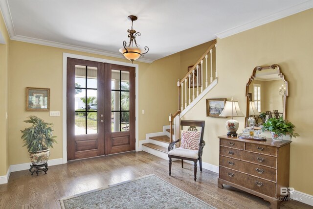 foyer with ornamental molding, hardwood / wood-style flooring, and french doors