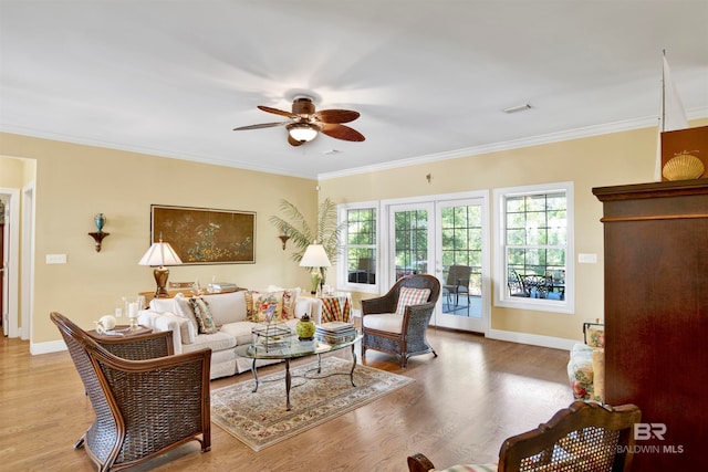 living room with wood-type flooring, crown molding, and ceiling fan