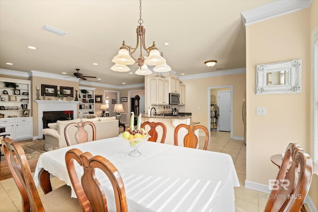 dining area featuring crown molding, light tile patterned floors, and ceiling fan with notable chandelier