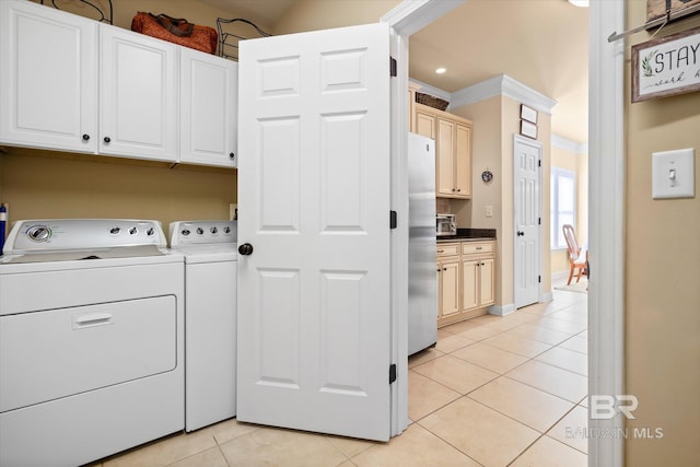 laundry room featuring light tile patterned flooring, cabinets, washer and dryer, and ornamental molding