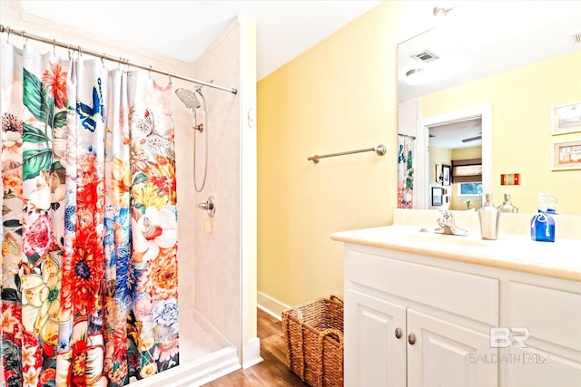 bathroom featuring hardwood / wood-style flooring, a shower with shower curtain, and oversized vanity