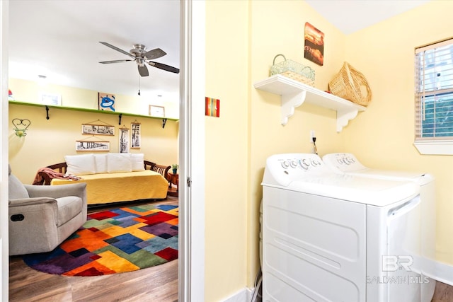 clothes washing area with wood-type flooring, washing machine and dryer, and ceiling fan