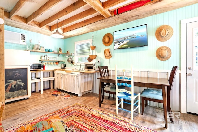 dining area with sink, beam ceiling, hardwood / wood-style flooring, and a wall unit AC