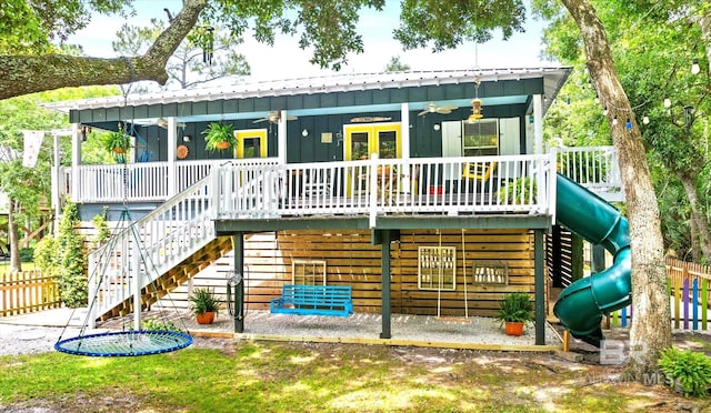 rear view of property featuring ceiling fan and a playground