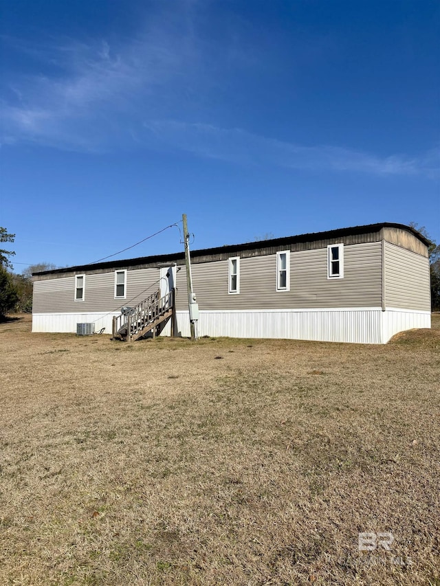 back of house with cooling unit and a yard