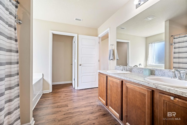 bathroom with wood-type flooring, curtained shower, and vanity