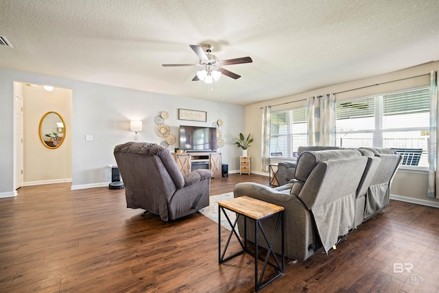 living room featuring a textured ceiling, ceiling fan, and dark hardwood / wood-style floors