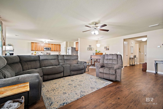 living room with ceiling fan, dark hardwood / wood-style flooring, and a textured ceiling