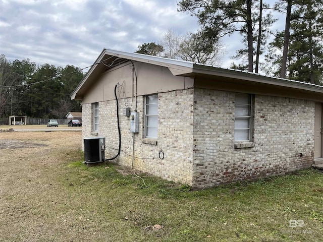 view of property exterior with central air condition unit and a yard