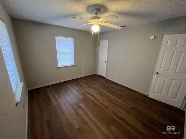 unfurnished bedroom with a textured ceiling, ceiling fan, and dark hardwood / wood-style floors