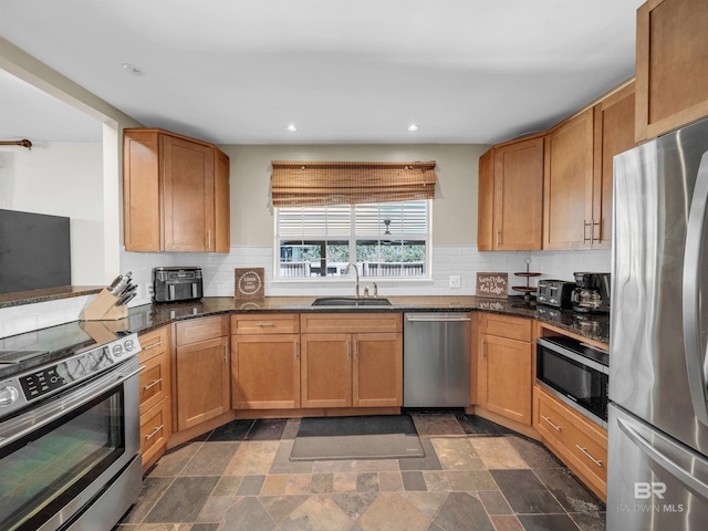 5410 Florida Ave, Orange Beach, AL 36561 - kitchen featuring decorative backsplash, dark stone counters, stainless steel appliances, recessed lighting, and a sink