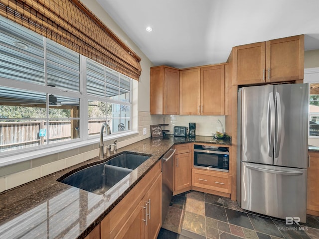 5410 Florida Ave, Orange Beach, AL 36561 - kitchen with appliances with stainless steel finishes, dark stone countertops, a sink, backsplash, and stone tile floors