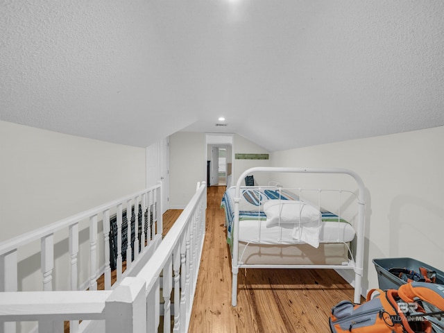 5410 Florida Ave, Orange Beach, AL 36561 - bedroom with vaulted ceiling, wood finished floors, and a textured ceiling
