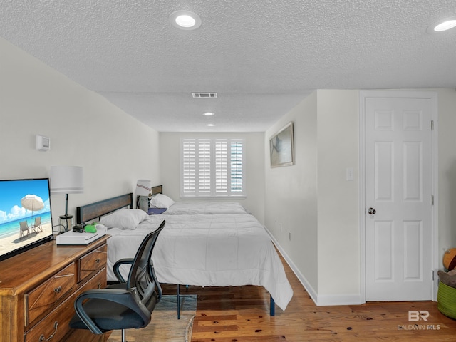 5410 Florida Ave, Orange Beach, AL 36561 - bedroom with baseboards, visible vents, a textured ceiling, and wood finished floors
