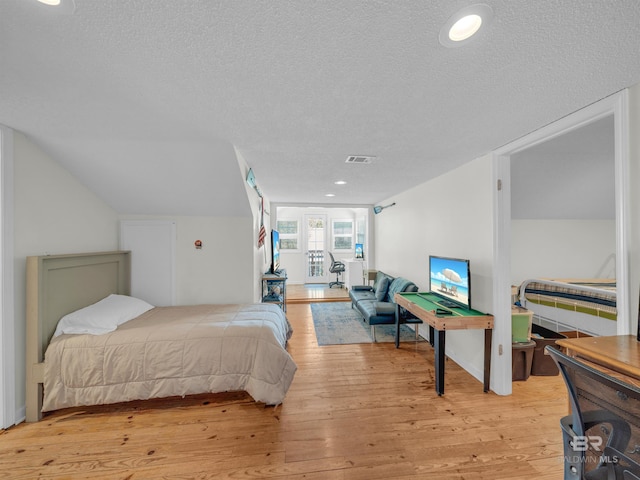 5410 Florida Ave, Orange Beach, AL 36561 - bedroom featuring a textured ceiling, light wood-style floors, vaulted ceiling, and visible vents