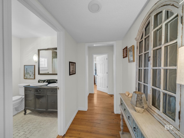 5410 Florida Ave, Orange Beach, AL 36561 - corridor with baseboards, a textured ceiling, wood finished floors, and a sink