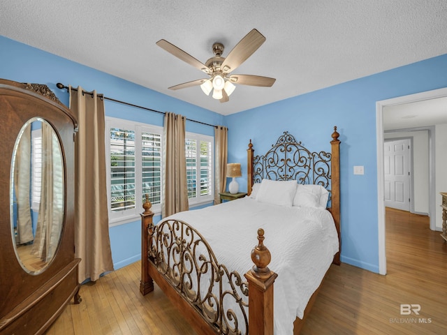 5410 Florida Ave, Orange Beach, AL 36561 - bedroom with baseboards, a textured ceiling, wood finished floors, and a ceiling fan