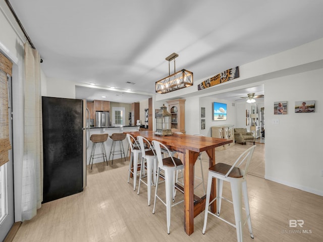 5410 Florida Ave, Orange Beach, AL 36561 - dining room featuring ceiling fan with notable chandelier, light wood-style floors, and baseboards