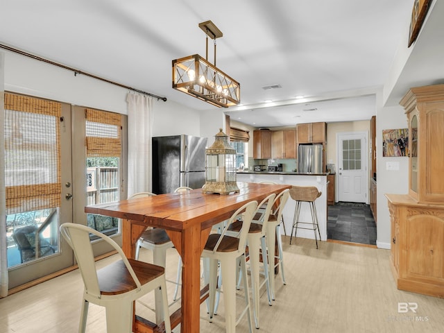 5410 Florida Ave, Orange Beach, AL 36561 - dining area featuring a wealth of natural light, visible vents, a notable chandelier, and light wood-style floors