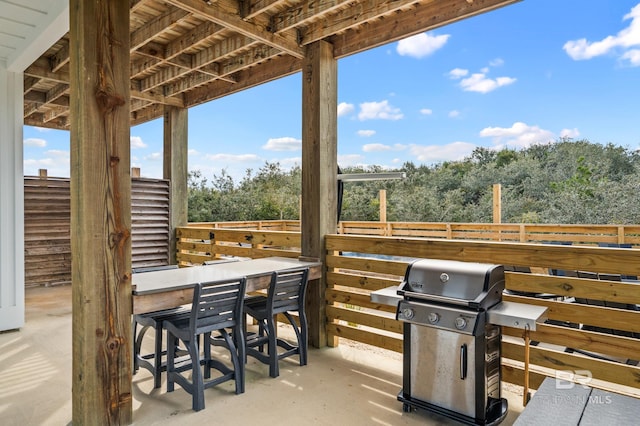 view of patio with outdoor dry bar, area for grilling, and fence