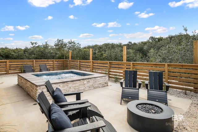 view of patio featuring an outdoor hot tub and a view of trees