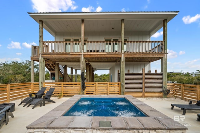 back of house with a wooden deck, fence, board and batten siding, and a patio