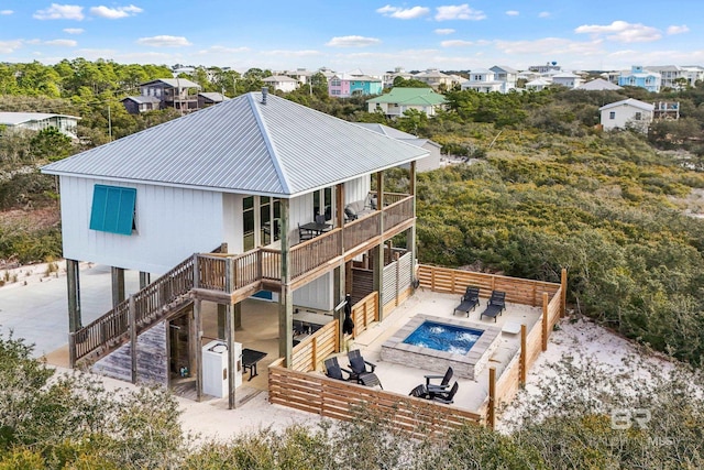 back of house with a hot tub, a patio area, metal roof, fence, and stairs