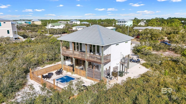 back of property featuring metal roof, driveway, and a balcony