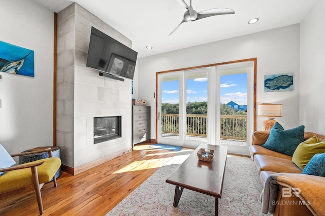 living room featuring a fireplace, light wood finished floors, recessed lighting, a ceiling fan, and baseboards