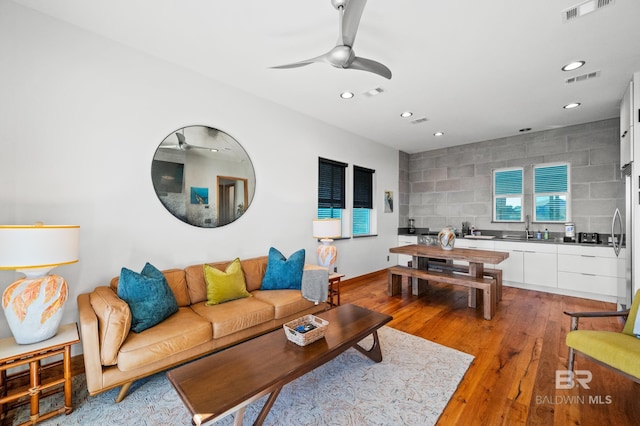 living area with light wood-type flooring, visible vents, and recessed lighting