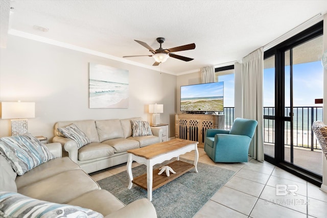 tiled living room with expansive windows, a water view, ceiling fan, crown molding, and a textured ceiling