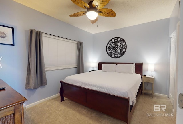 bedroom with a ceiling fan, baseboards, and light carpet