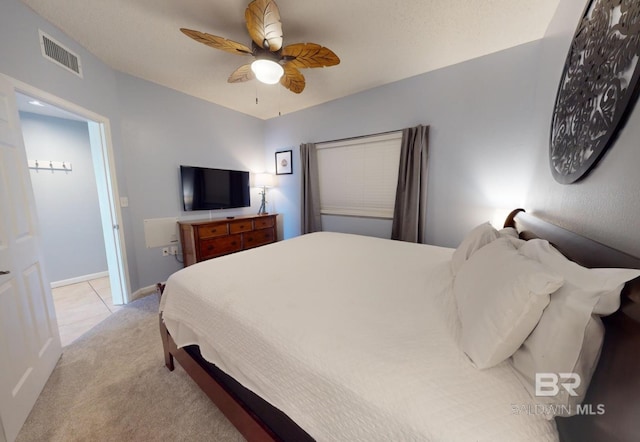 bedroom featuring ceiling fan, baseboards, visible vents, and light carpet