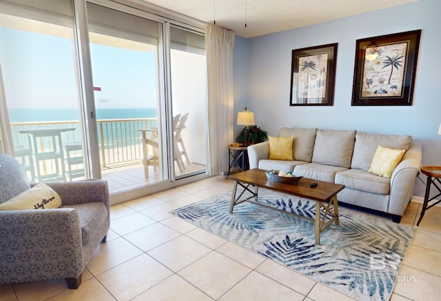 tiled living room featuring a water view and a textured ceiling