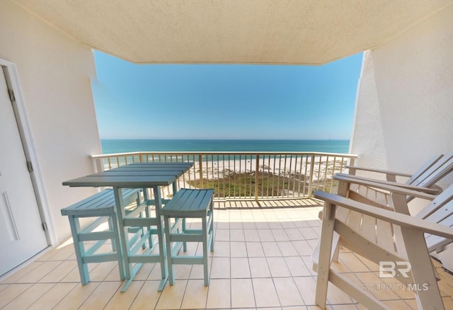 balcony featuring a water view and a view of the beach