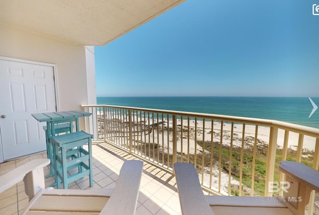 balcony featuring a view of the beach and a water view