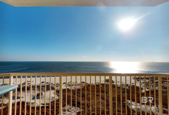 balcony with a water view and a view of the beach