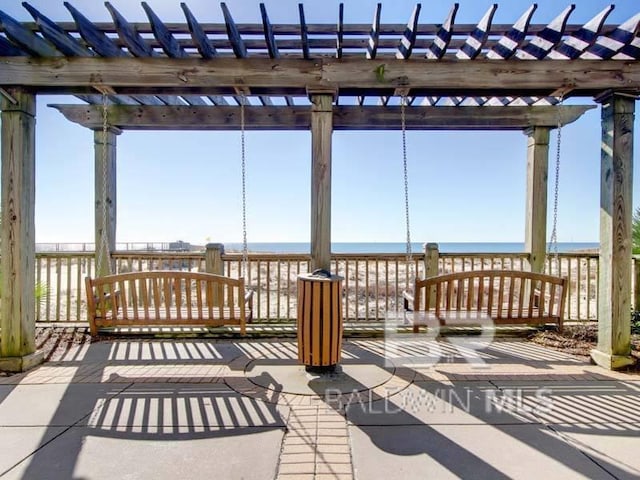 view of patio with a water view and a pergola