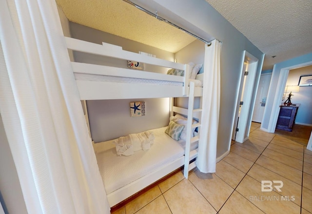 bedroom with light tile patterned floors and a textured ceiling