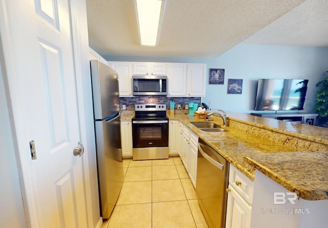 kitchen with white cabinetry, light tile patterned floors, appliances with stainless steel finishes, and a sink