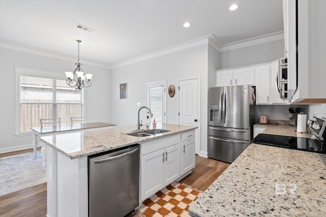 kitchen with stainless steel appliances, white cabinetry, sink, and a kitchen island with sink